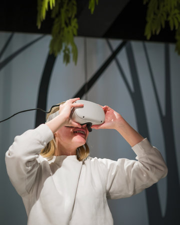 Teenager girl wearing VR headsets having fun in the virtual reality showroom, making head and arms...