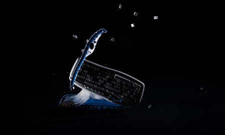 Destroying and hitting a computer keyboard on a floor, particles flying in the air, slow motion...