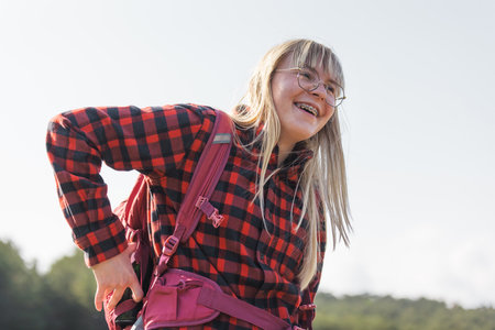 Female hiker with a backpack walking and following the trail uphill, enjoying the nature. Inspiration and healthy lifestyles concepts.の写真素材