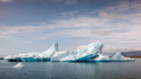 Icelandic glacial scenery, magnificent ice form, iceberg floating in the calm blue water. Unique nature sights and trip concepts.の写真素材