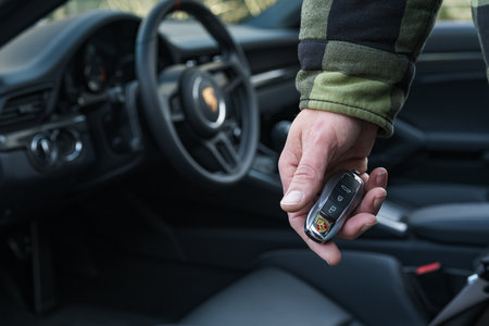 Slovenia, Ljubljana - 31 January 2024: Man holding Porsche car key in handのeditorial素材