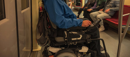 Man with disability with electric wheelchair on train. Inclusive and accessible public transportation concept.の写真素材