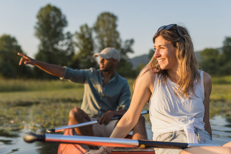 Couple spending a hot summer afternoon on the lake, gently paddling a canoe on calm water. Canoeing and healthy lifestyle concepts.の写真素材