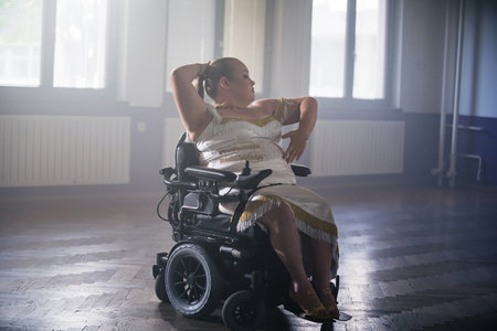 Woman with disability training for a competition, performing a solo freestyle dance. Wheelchair dancing sport concept.の写真素材