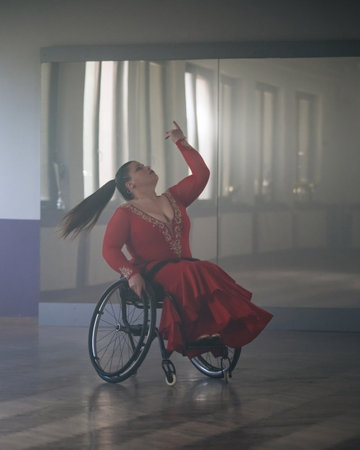 Beautiful dance in a wheelchair of a woman with disability at a dancing studio. Para dance sport.の写真素材