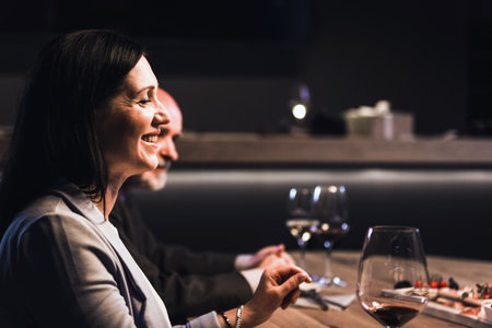 People drinking wine and eating cold cut meat in a wine cellar.の写真素材