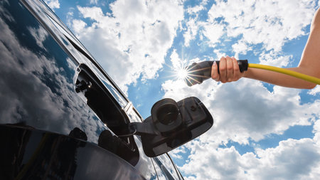 Woman opening an electric car charging socket cap and plugging in a charger