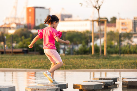 Children playing at park on a hot summer sunset dayの写真素材