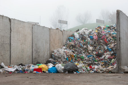 Landfill site, a pile of different junk disposal in the concrete section for unsorted waste materialsの写真素材