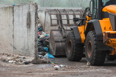 Heavy construction machine, front end loader moving along recycling center area, close up view....