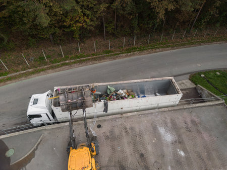 Waste loading operation, loader dumping trash in a truck on a site for the disposal of waste...