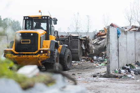 Heavy construction machine, front end loader moving along recycling center area, close up view....