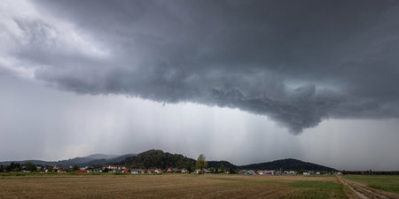 Destructive supercell storm bringing rain and wind over the farm fieldの写真素材