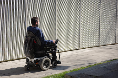 Man in a wheelchair using an accessible ramp.の写真素材