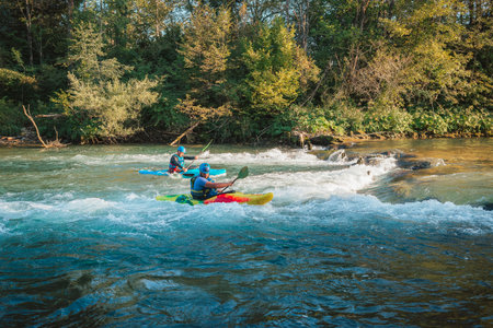 Whitewater kayaker paddling on the waters of river. Adrenaline seekers and nature lovers.の写真素材