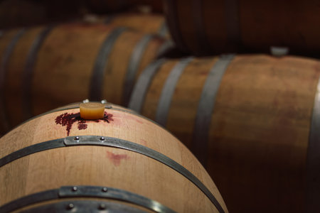 Stacked wooden barrels in a wine cellar, production and aging red wine in the traditional way
