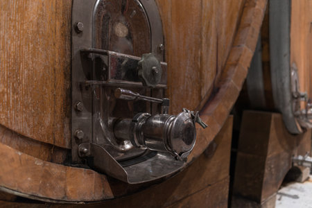 Stacked wooden barrels in a wine cellar, production and aging red wine in the traditional wayの写真素材