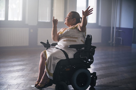 Woman with disability training for a competition, performing a solo freestyle dance. Wheelchair dancing sport concept.の写真素材