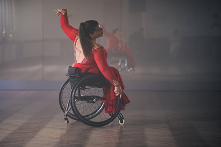 Beautiful dance in a wheelchair of a woman with disability at a dancing studio. Para dance sport.の写真素材