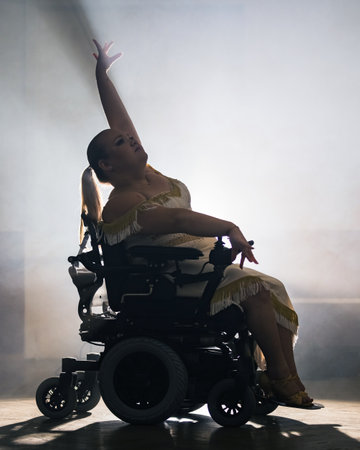 Woman practicing and performing a freestyle wheelchair dance at a dancing studio, wide shot. Dance sport concept.の写真素材