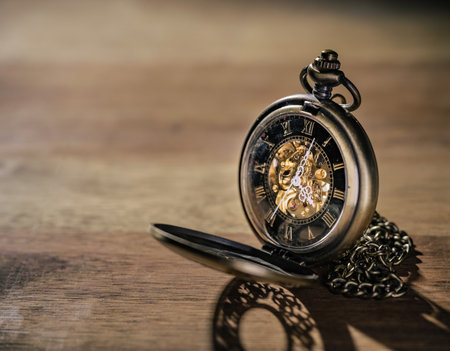 Golden antique elegant pocket watch ticking, five minutes to midnight, on a blurred background,...
