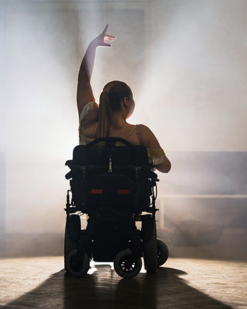 Woman practicing and performing a freestyle wheelchair dance at a dancing studio, wide shot. Para dance sport concept.の写真素材
