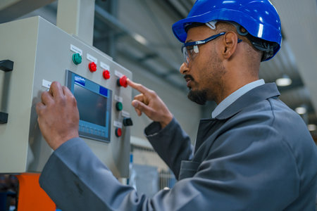 African American professional, a factory engineer updating industrial control panel. Modern industry, people, and automating concepts.の写真素材