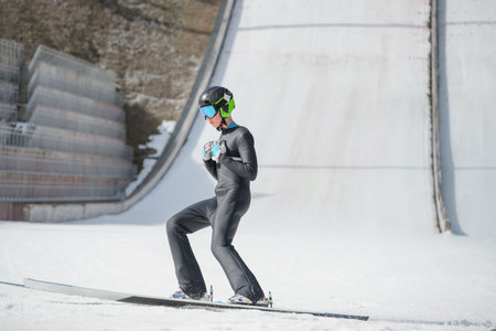 A ski jumper during training at a winter sports facility. Winter sports competition concept.の写真素材