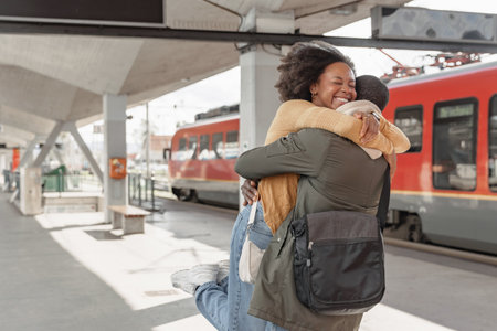 African American couple meeting at a railway station near arrived train, expressing excitement for their upcoming journey together.の写真素材