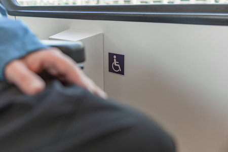 Young wheelchair user traveling by train, watching a landscape through the window.の写真素材