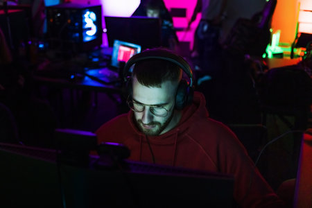 Man gamer participant in a gaming competition, sitting in front of a computer monitor and playing...