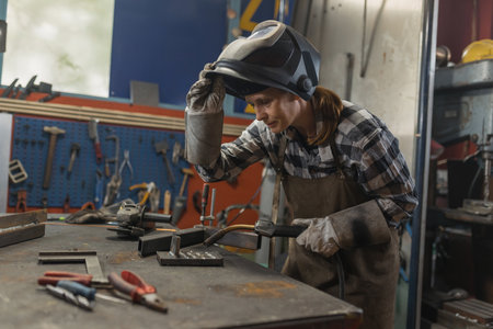 Woman welder successfully performing the MIG welding process in the family business workshop. Craftswoman, inspiration, and personal growth concepts.の写真素材