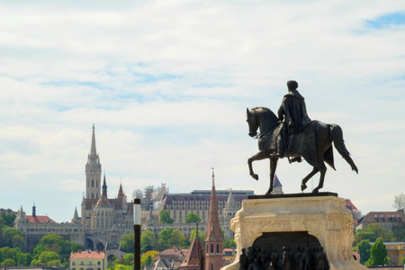 A striking equestrian statue stands prominently in Budapest, with stunning architectural landmarks and greenery in the background. This scene captures the essence of Hungarys rich history.の写真素材