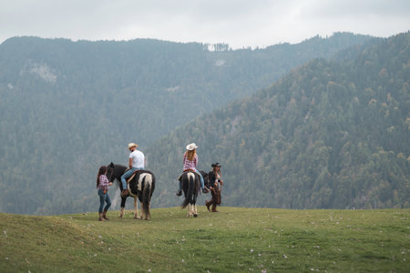 Riding school participants bonding with horses under the guidance of professional instructors during a lesson in a beautiful natural environmentの写真素材