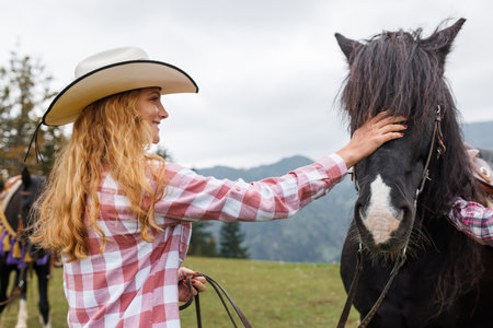 Smiling woman bonding with a horse, learning the basics of western riding in a stunning natural settingの写真素材