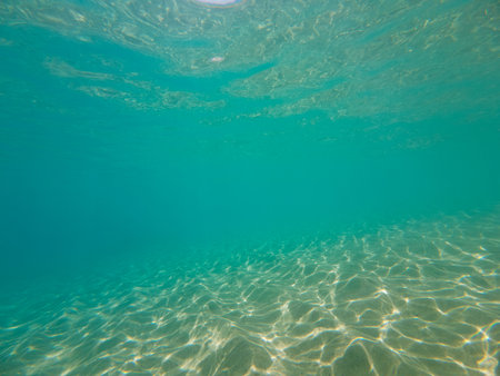 Seabed texture, blue turquoise and white sandy sea floor, water waves reflection, color and light play, top down shot. Summer background concept.の写真素材