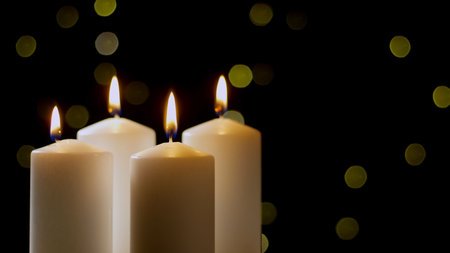 Four white Advent candles illuminate a dark background, casting a warm and inviting atmosphere at december for Christmas.の写真素材