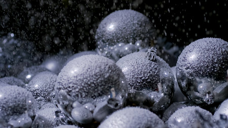 Shimmering silver ornaments are adorned with a thick layer of frost, creating a wintry atmosphere in...