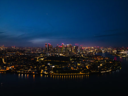 A stunning view of London at night, featuring illuminated skyscrapers and the River Thames, with vibrant city life all around.の写真素材