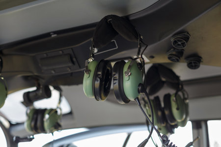 Headsets hang in the cockpit, ready for use during helicopter operations. The environment is prepared for flight.の写真素材