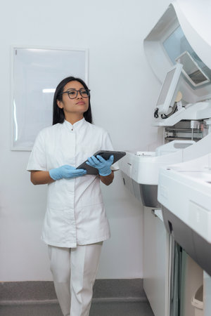 Female researcher in clinical laboratory working with automated medical technologies. Prevention, screening, and diagnosis concepts.の写真素材