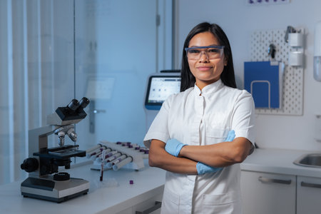 Portrait of a smiling confident young Asian woman, clinic laboratory technician in the workplace...