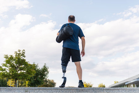 Man with disability performs workout routines while wearing a prosthetic leg in an urban outdoor...