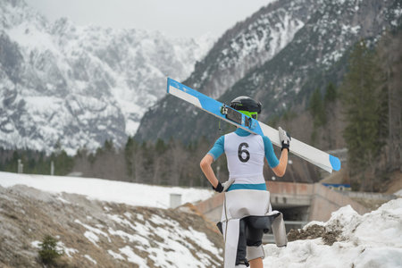 Ski jumper walking with skis after hard training in winter at outrunの写真素材