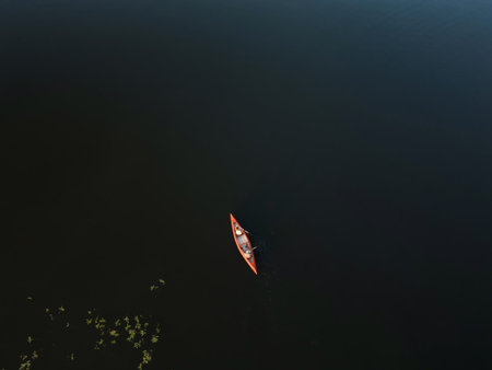 A couple kayaks on a lake, enjoying a fun outdoor activity with nature all around. They share a...