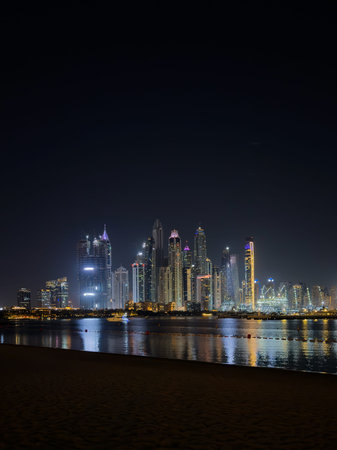 Vertical skyline of Dubai city skyscrapers at night, illuminated skyline with magical reflections on...