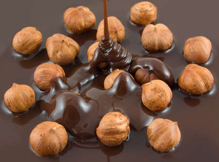 Chocolate flows on nuts. Tasty look - abstract food background