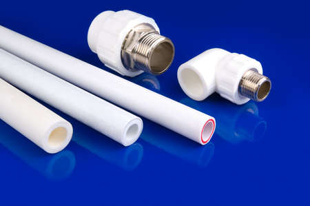 White plastic fittings to use in hot and cold water supply lines. Blue background.