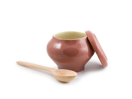 Empty ceramic pot and wooden spoon on a white background. Isolated の写真素材