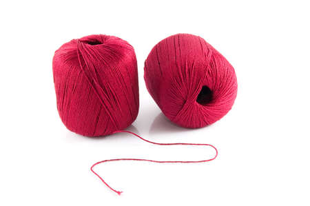 two red bobbin of thread on a white background